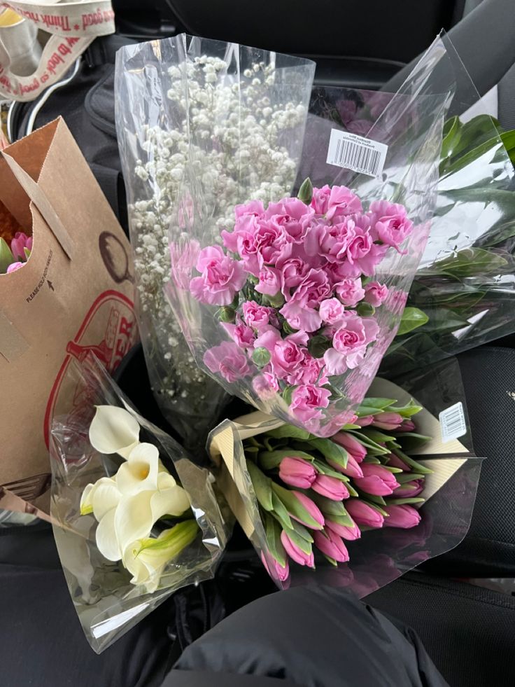 bouquets of pink and white flowers sitting on the back seat of a car