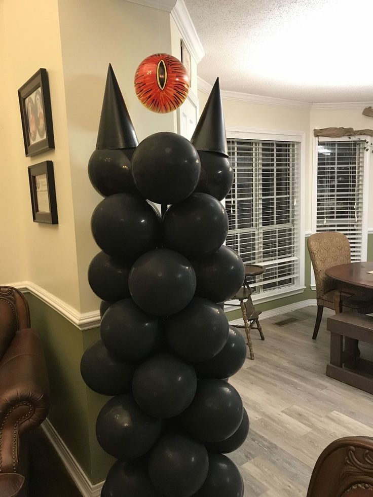 black balloons are stacked on top of each other in the middle of a living room