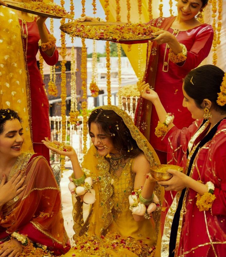 three women dressed in red and yellow are getting married