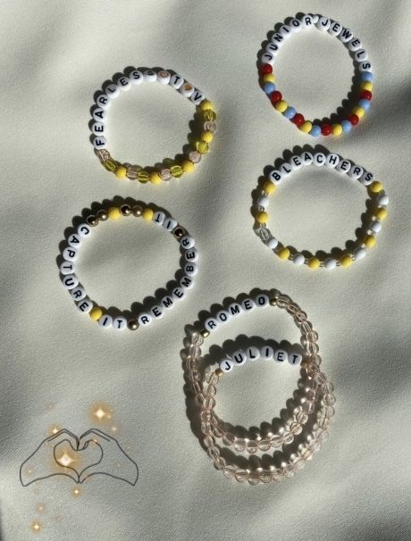 four bracelets with beads are laying on a sheet