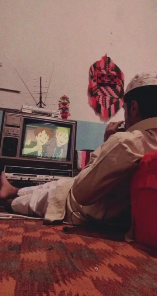 a man sitting on the floor watching tv