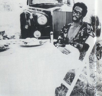 a man sitting at a table in front of an old truck