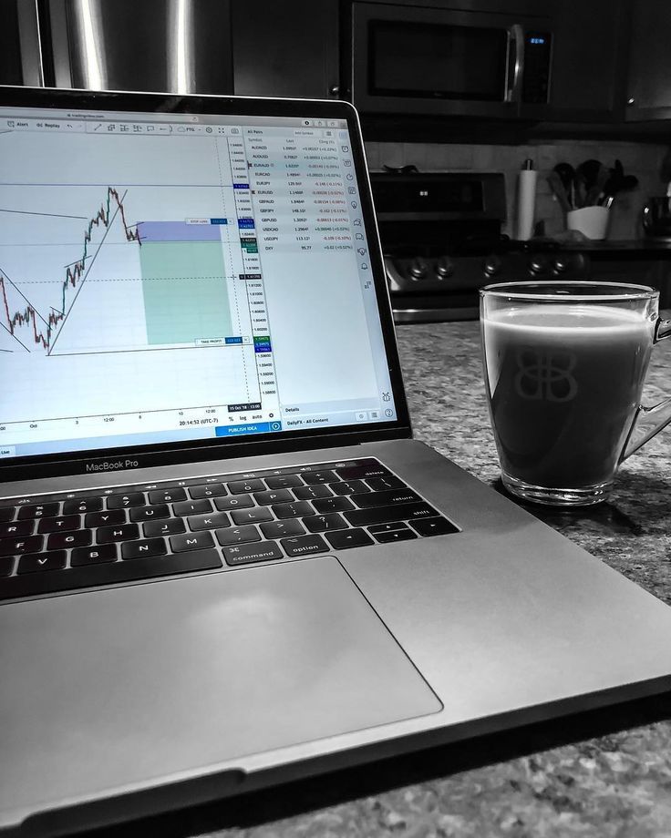 an open laptop computer sitting on top of a table next to a cup of coffee