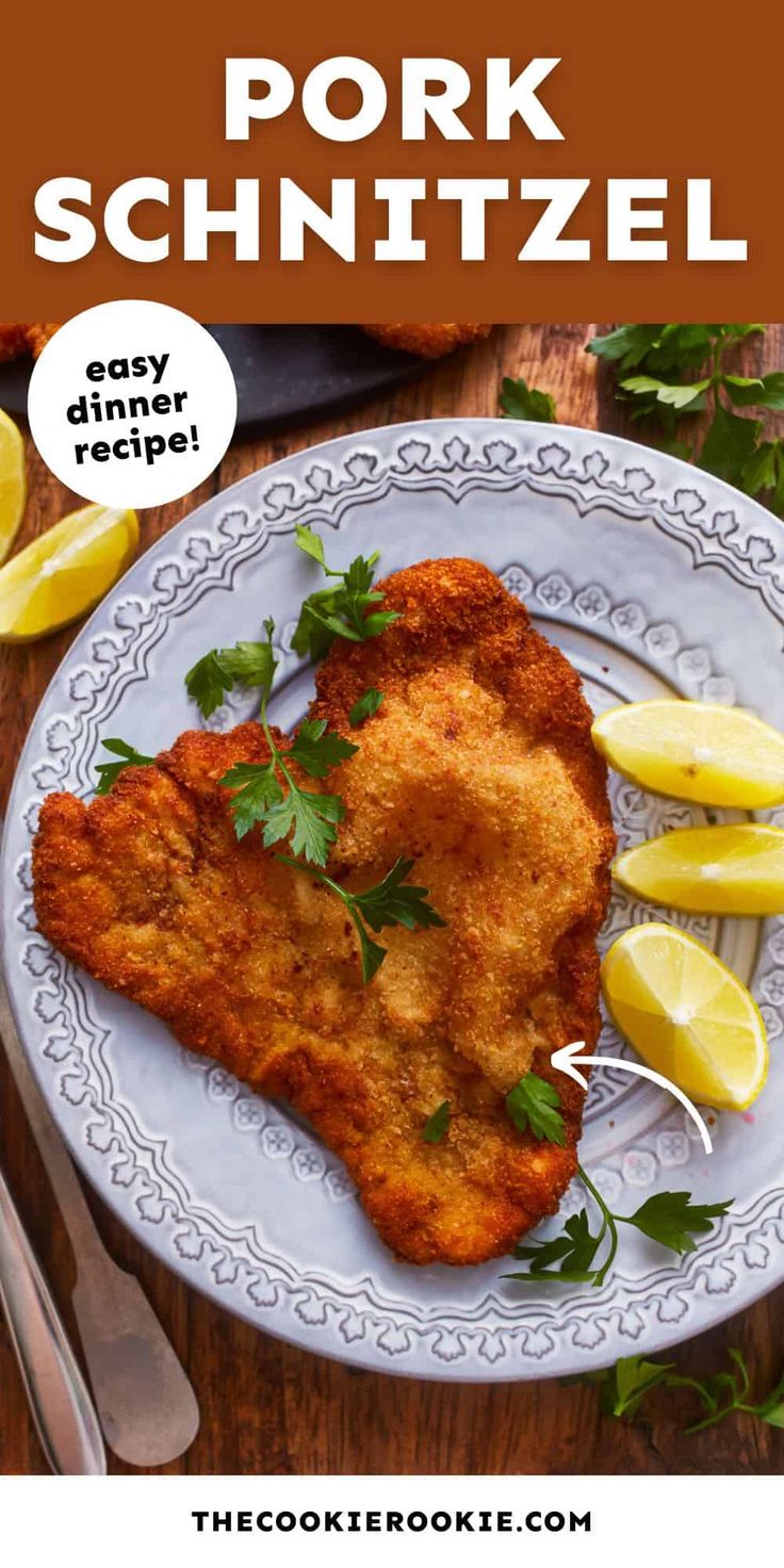 pork schnitzel on a plate with lemon wedges and parsley garnish