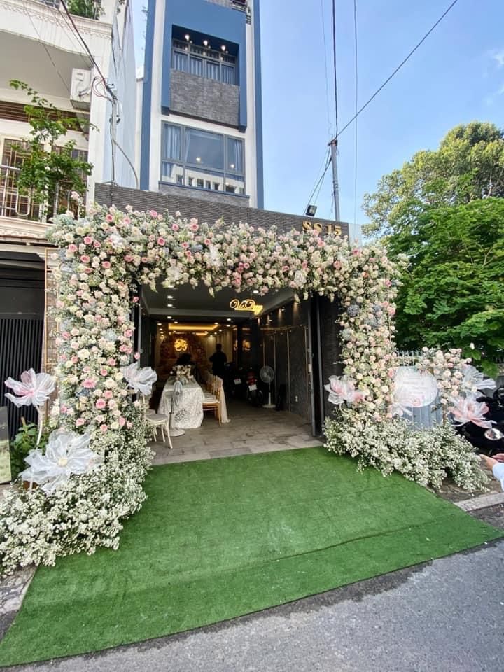 an entrance to a building decorated with flowers and greenery on the grass in front of it