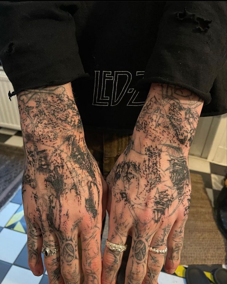 a person with tattoos on their arms and hands