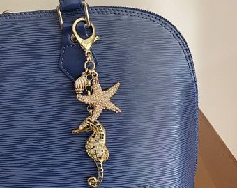 a blue purse with a starfish charm hanging from it