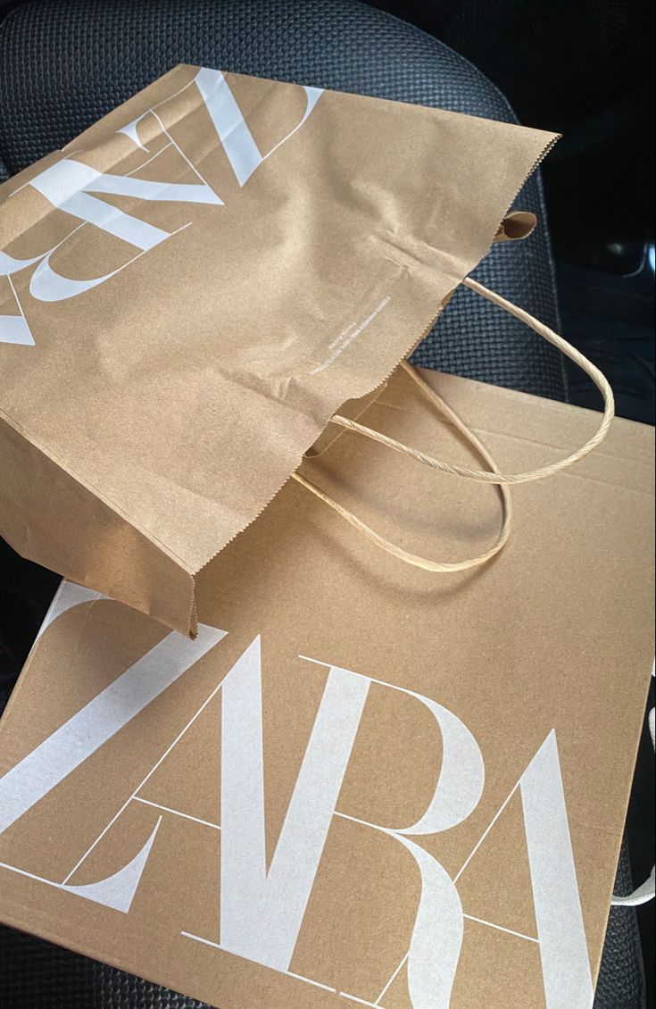 a brown paper bag sitting on top of an office chair next to another bag with the word avra printed on it