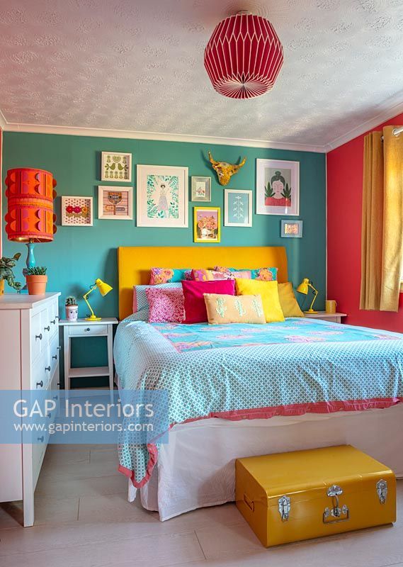 a bedroom decorated in bright colors with pictures on the wall