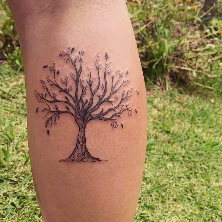 a woman's leg with a tree tattoo on it