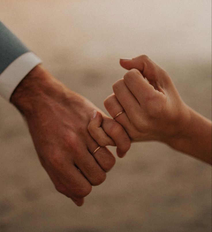 two people holding hands while standing next to each other