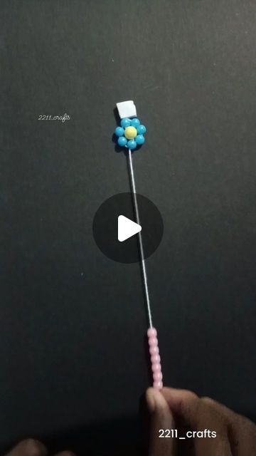 a person is holding a candy lollipop with a blue flower on the tip