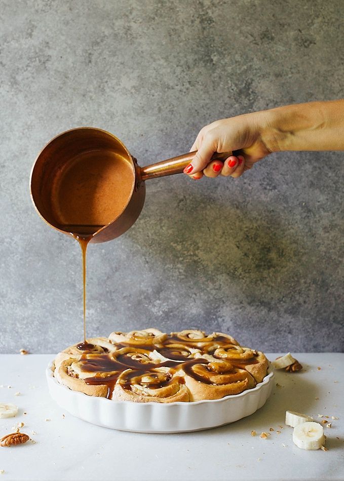 a person pouring caramel sauce over a pie