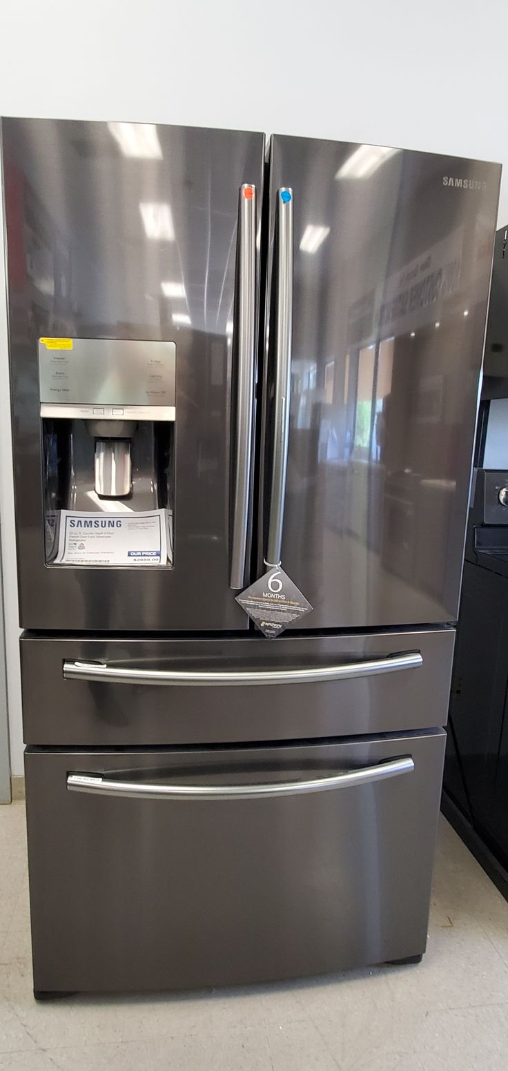 a stainless steel refrigerator with water dispenser on the front and ice maker on the back