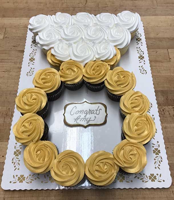 cupcakes arranged in the shape of a heart on top of a card board