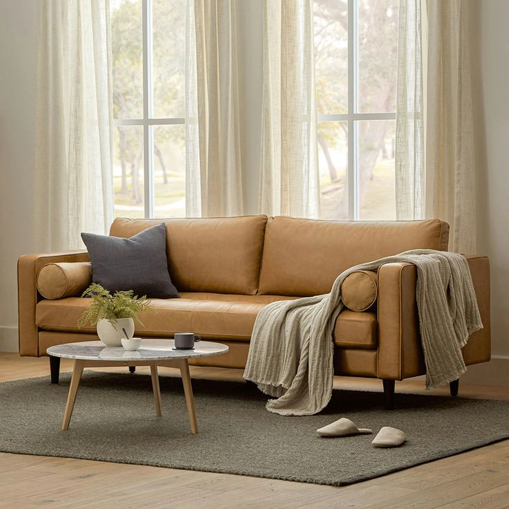 a living room scene with focus on the couch and coffee table in front of the window