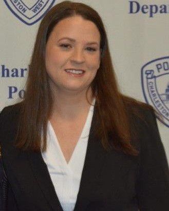 a woman standing in front of a wall with police badges on it's sides