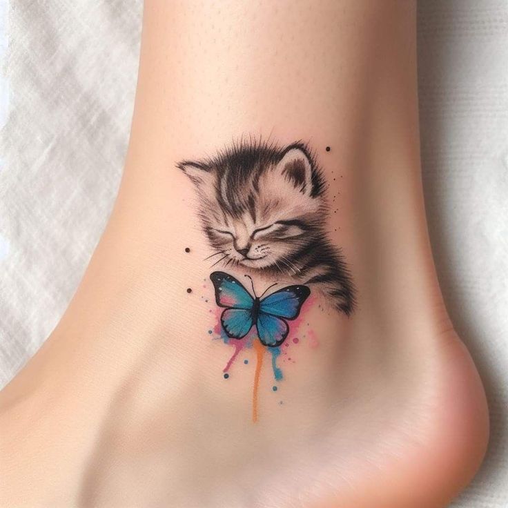 a small kitten with a blue butterfly on its foot