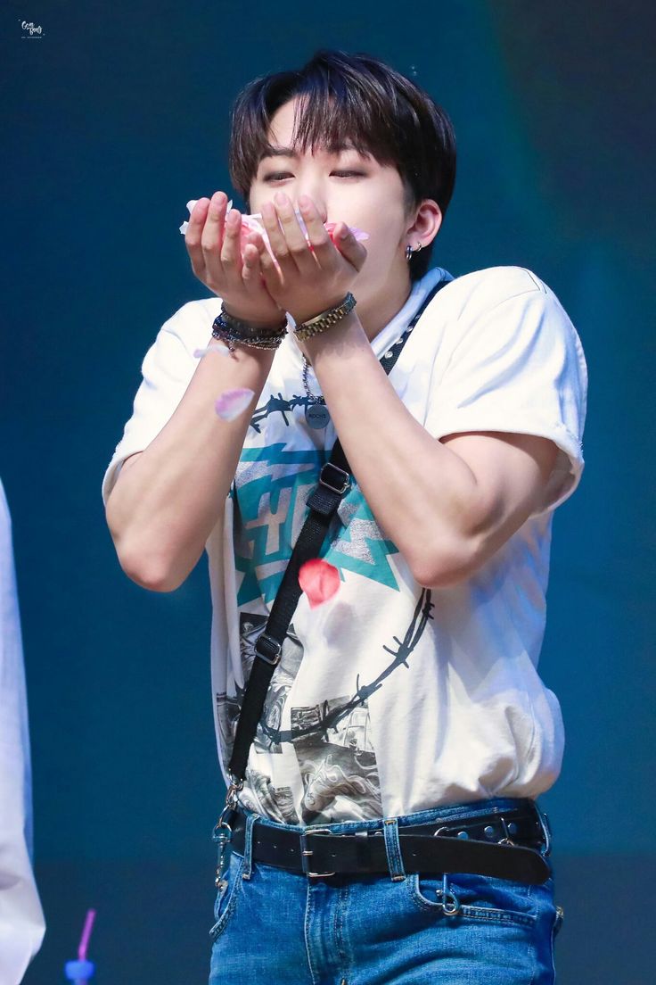 a young man holding his hands to his mouth while standing in front of a stage