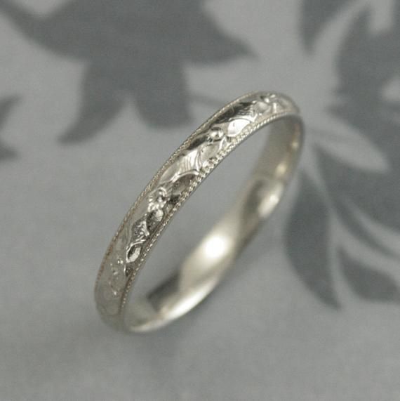 an antique style wedding ring with filigrees on the sides and floral designs