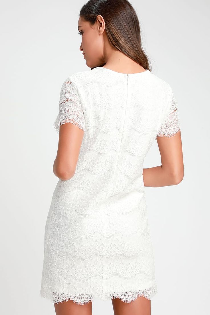 a woman is wearing a white dress with short sleeves and lace on the bottom,