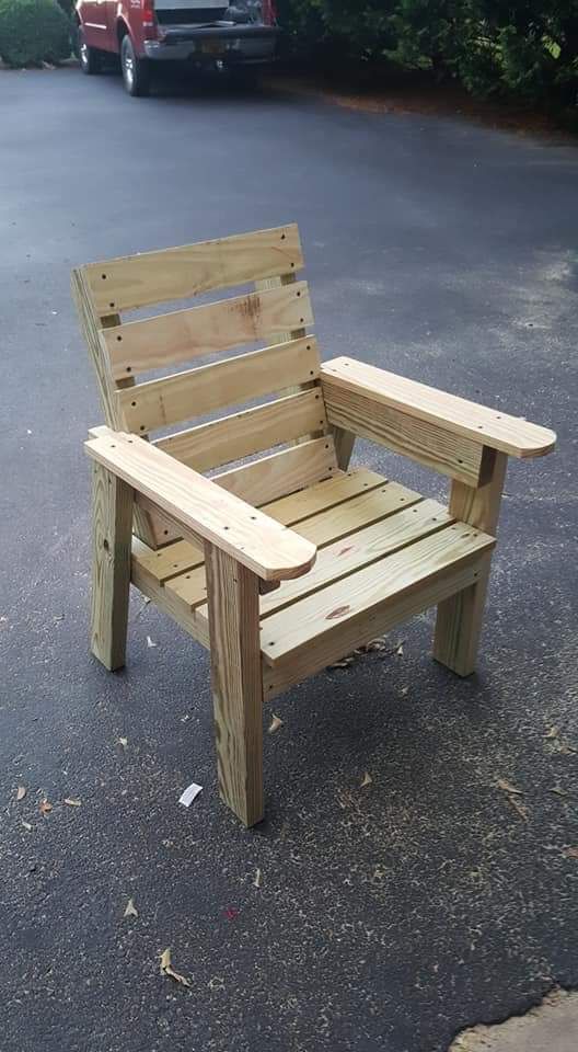 a wooden chair sitting in the middle of a parking lot