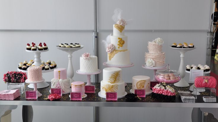 a table topped with lots of cakes and cupcakes