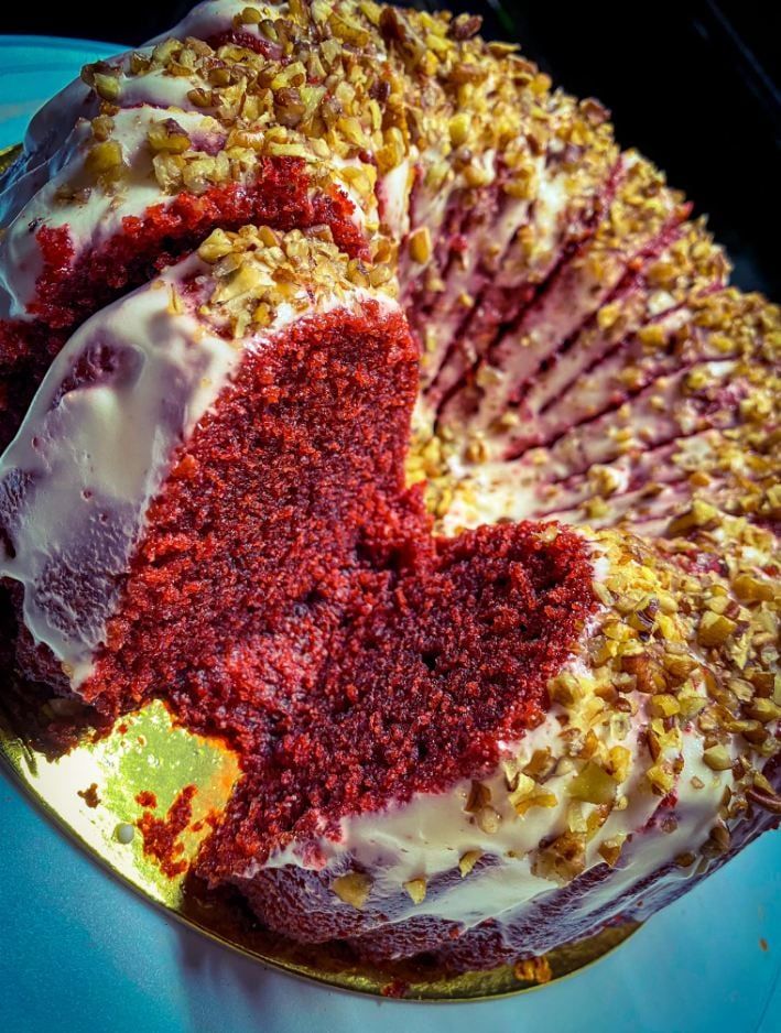 a red velvet cake with white frosting and sprinkles on a blue plate