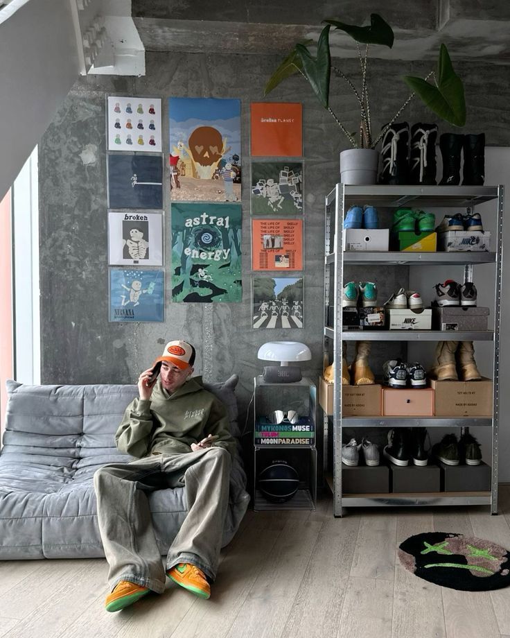 a man sitting on top of a couch next to a book shelf