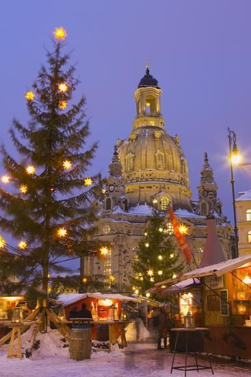 a christmas tree in front of a building with lights