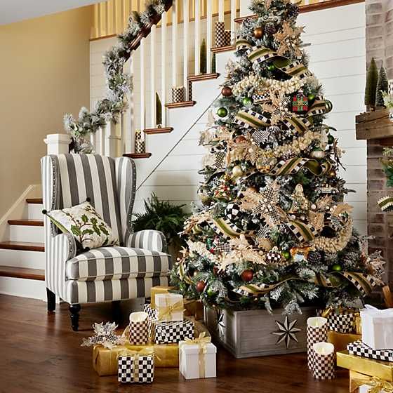 a decorated christmas tree sitting in the middle of a living room with presents under it