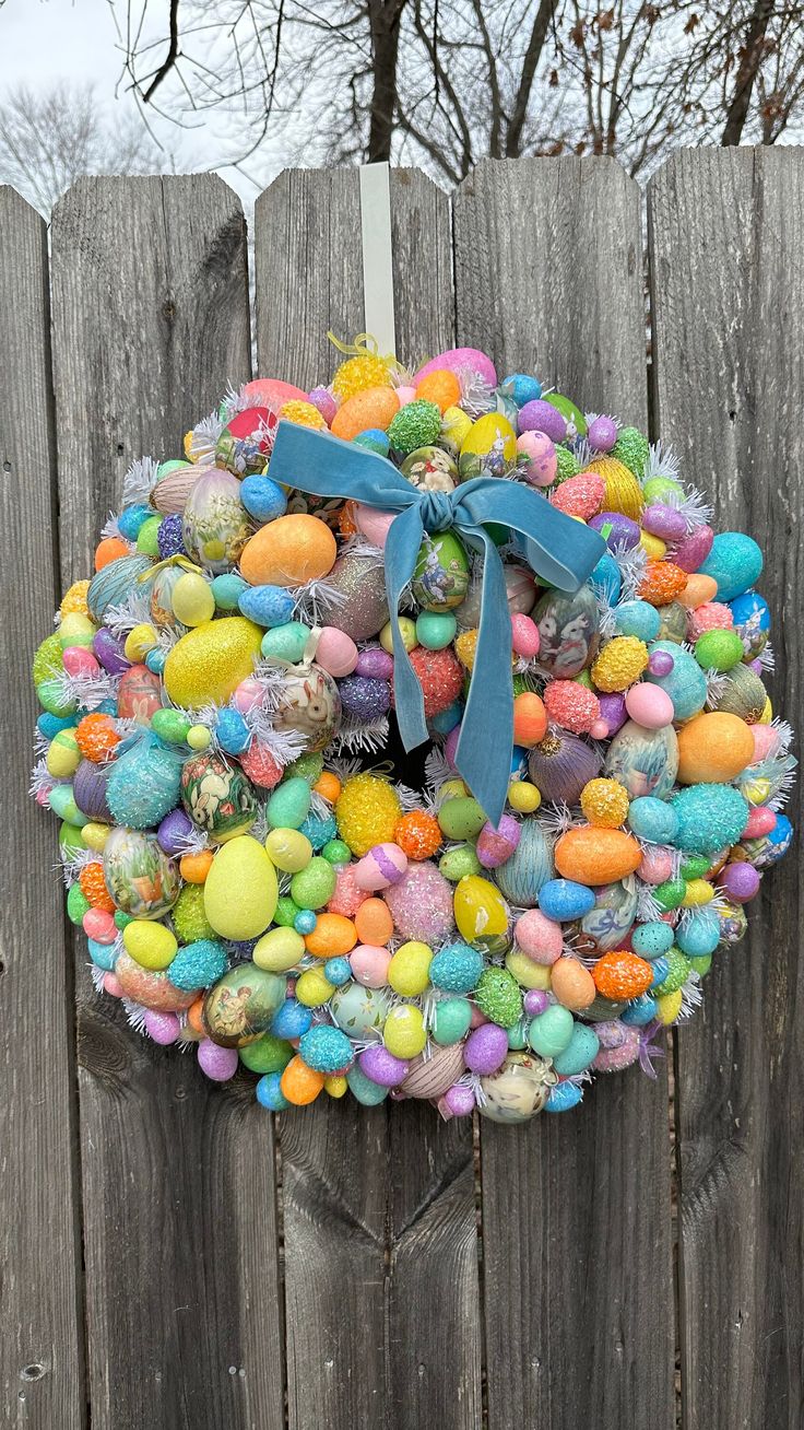 an easter wreath is hanging on a fence