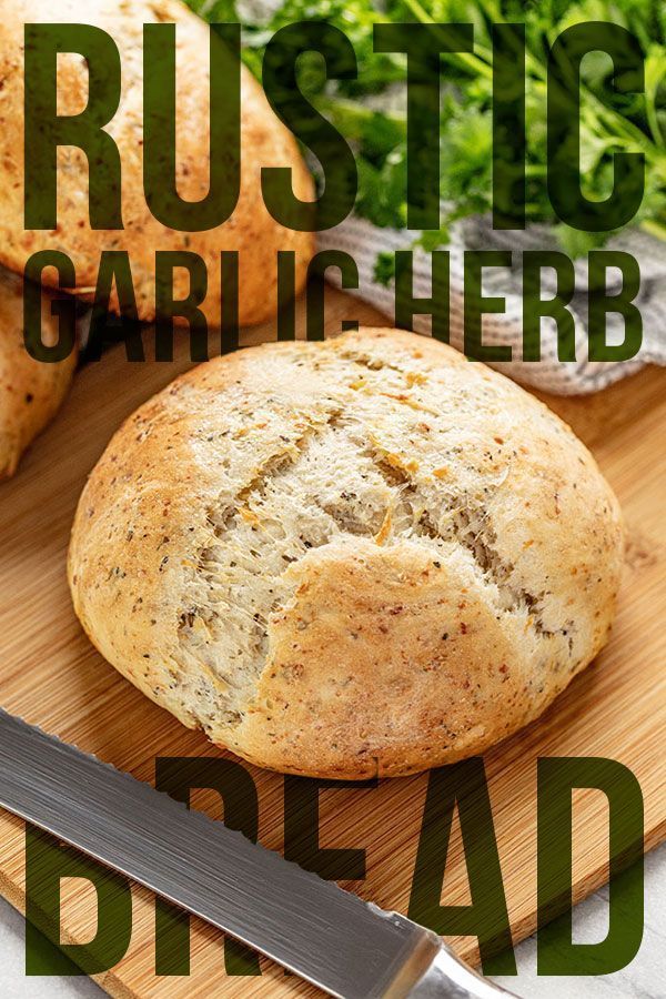 some bread on a cutting board with a knife next to it and the words rustic garlic herb bread