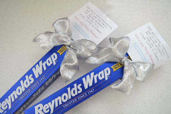 two rolls of candy wrapped in silver foil with a bow on it's end