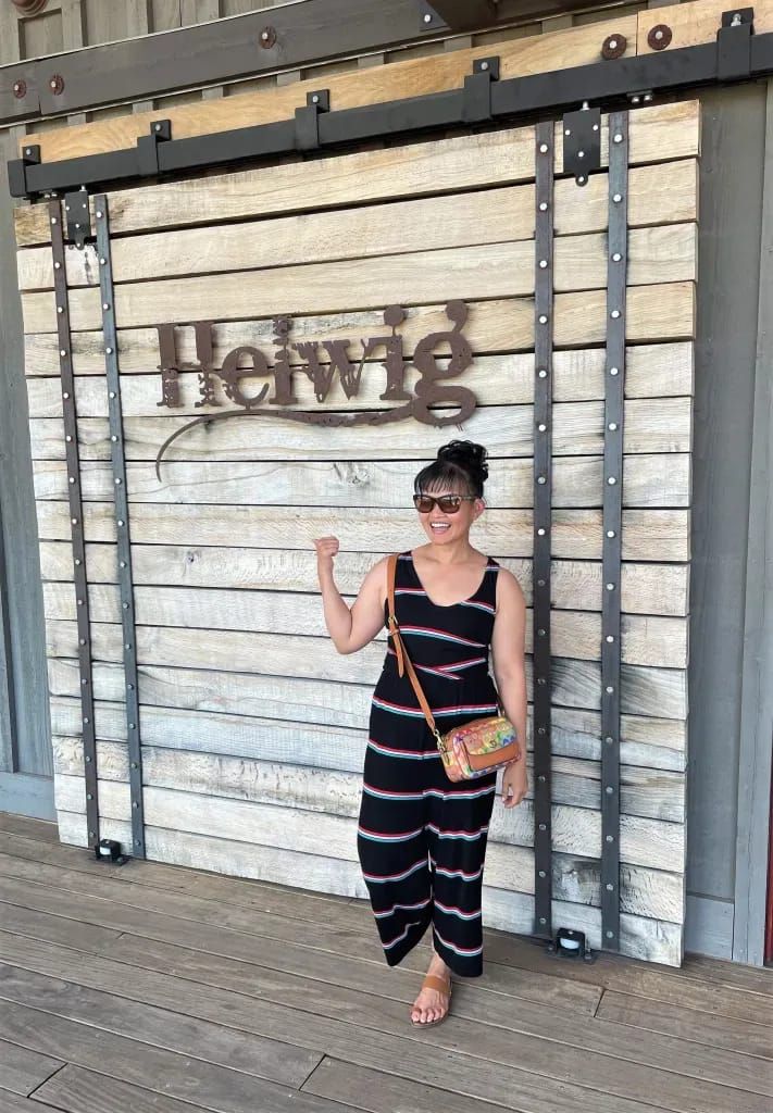 a woman standing in front of a building with a sign on the wall that says honey's