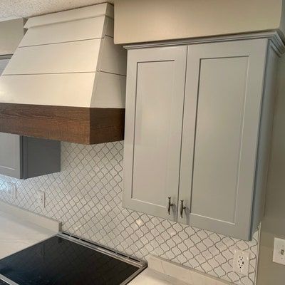 a stove top oven sitting inside of a kitchen next to white counter tops and cabinets