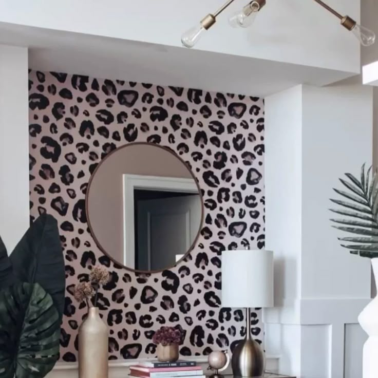 a living room with leopard print wallpaper and a round mirror on the wall above it