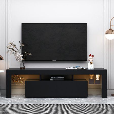 a flat screen tv sitting on top of a black entertainment center in a living room