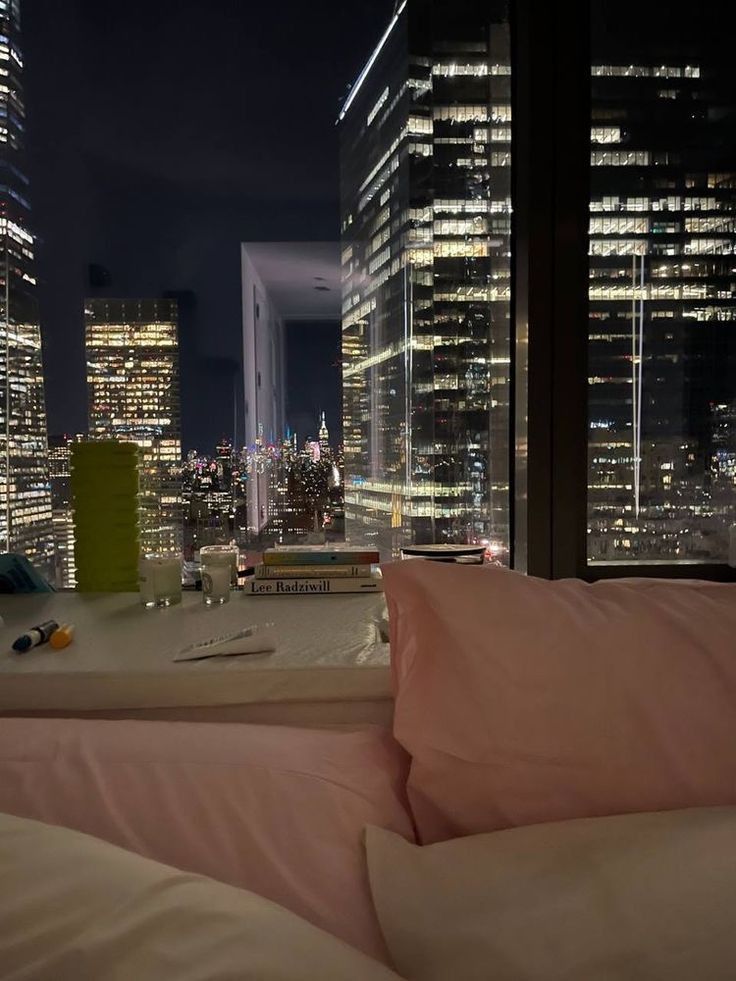 a view of the city at night from a bed