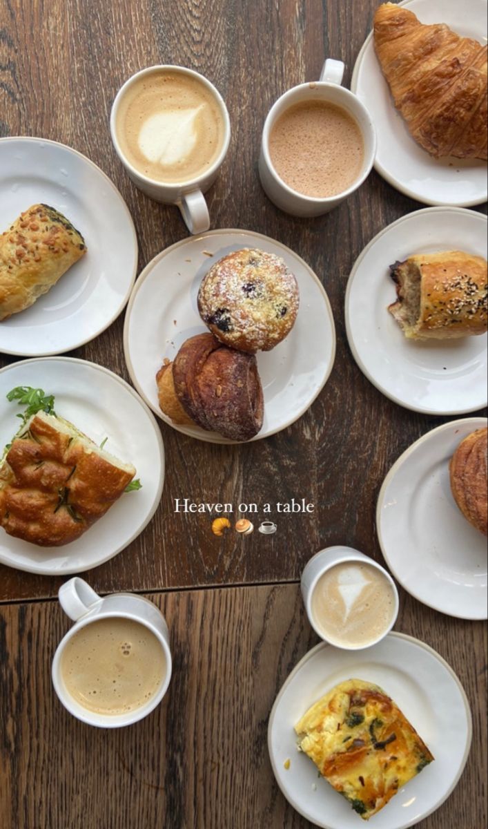 a table topped with lots of white plates filled with different types of breakfast foods and drinks