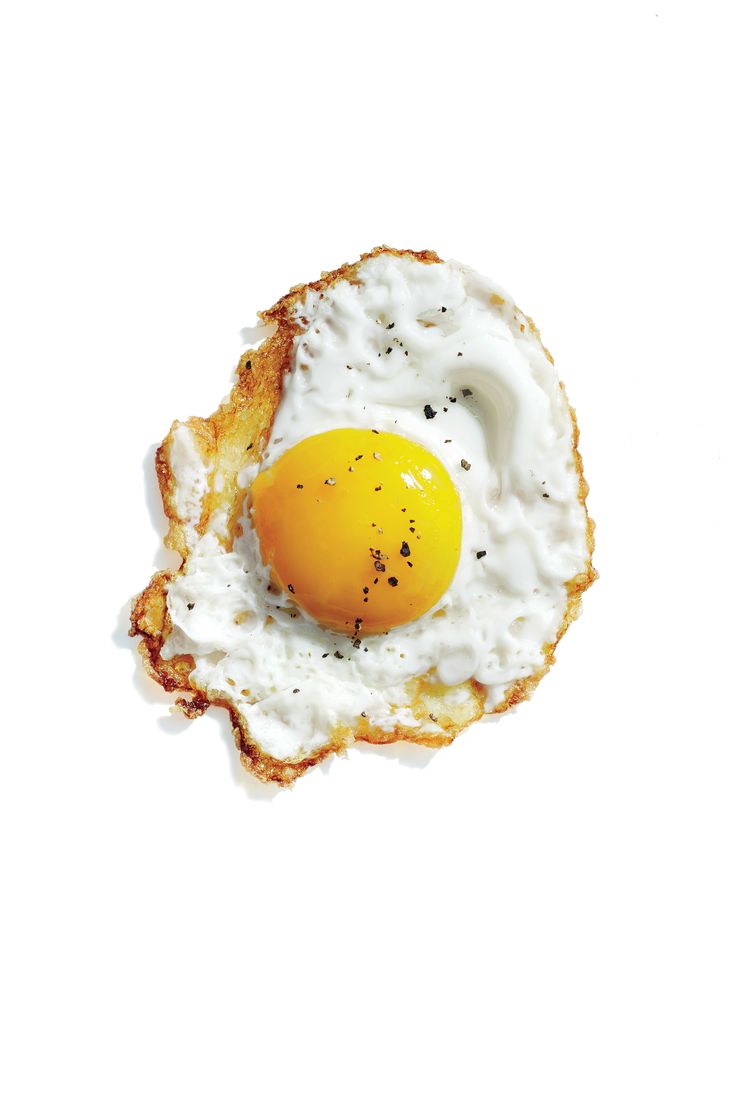 an egg is in the middle of some toasted bread on a white surface with black sprinkles