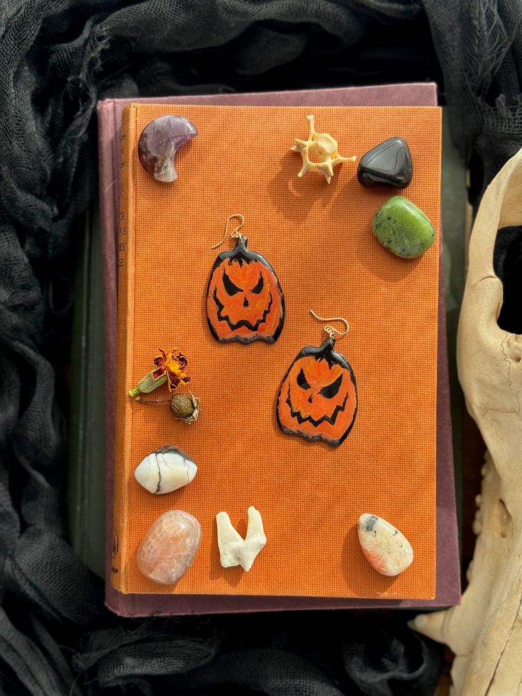 an orange book with halloween decorations on it and a skull in the background next to it