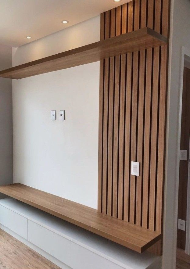 an empty room with wood paneling on the wall and wooden shelves in front of it