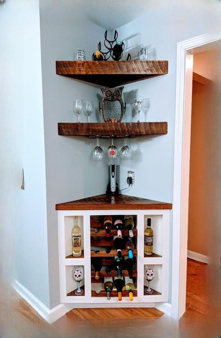 a wine rack in the corner of a room with shelves filled with bottles and glasses