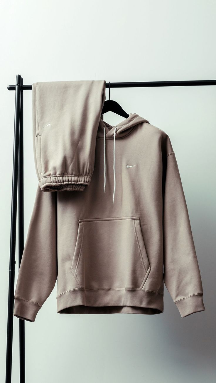 an unisex sweatshirt hanging on a clothes rack with a pair of pants attached to it