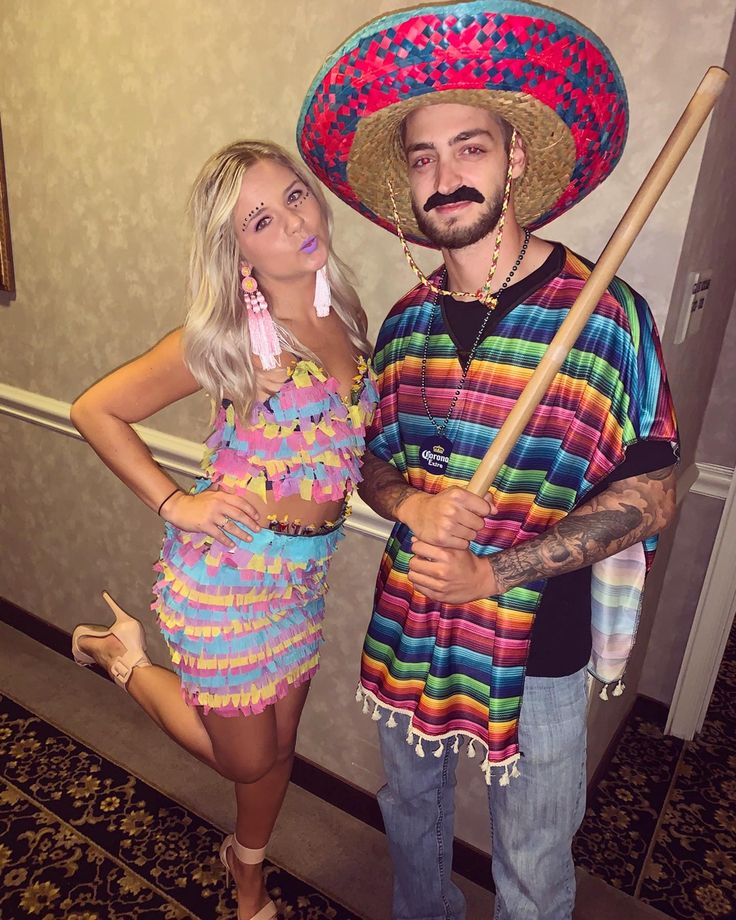 a man in a sombrero standing next to a woman wearing a colorful dress