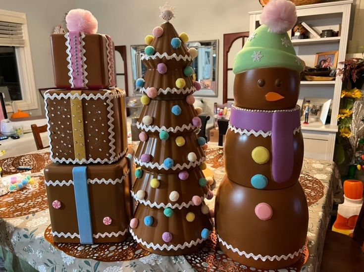 three decorated christmas trees sitting on top of a table