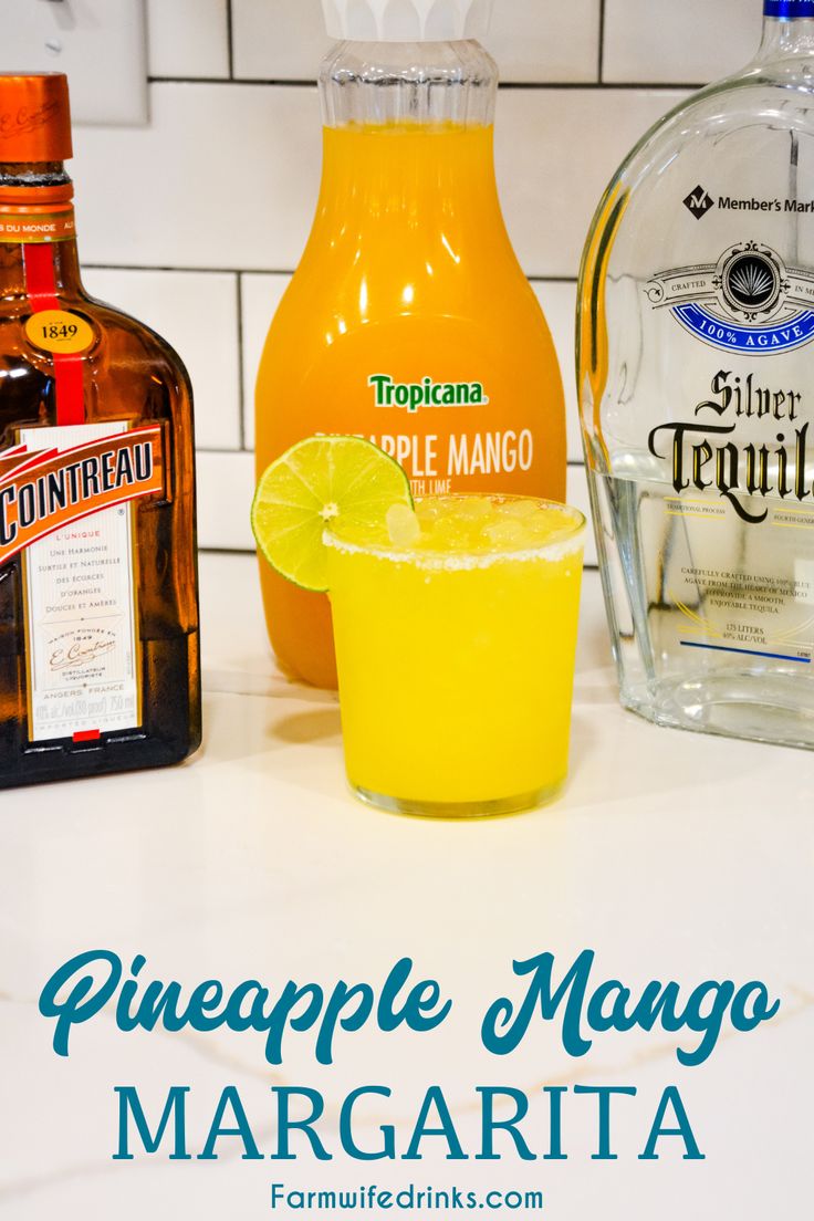 there is a bottle of pineapple mango margarita next to a glass of orange juice