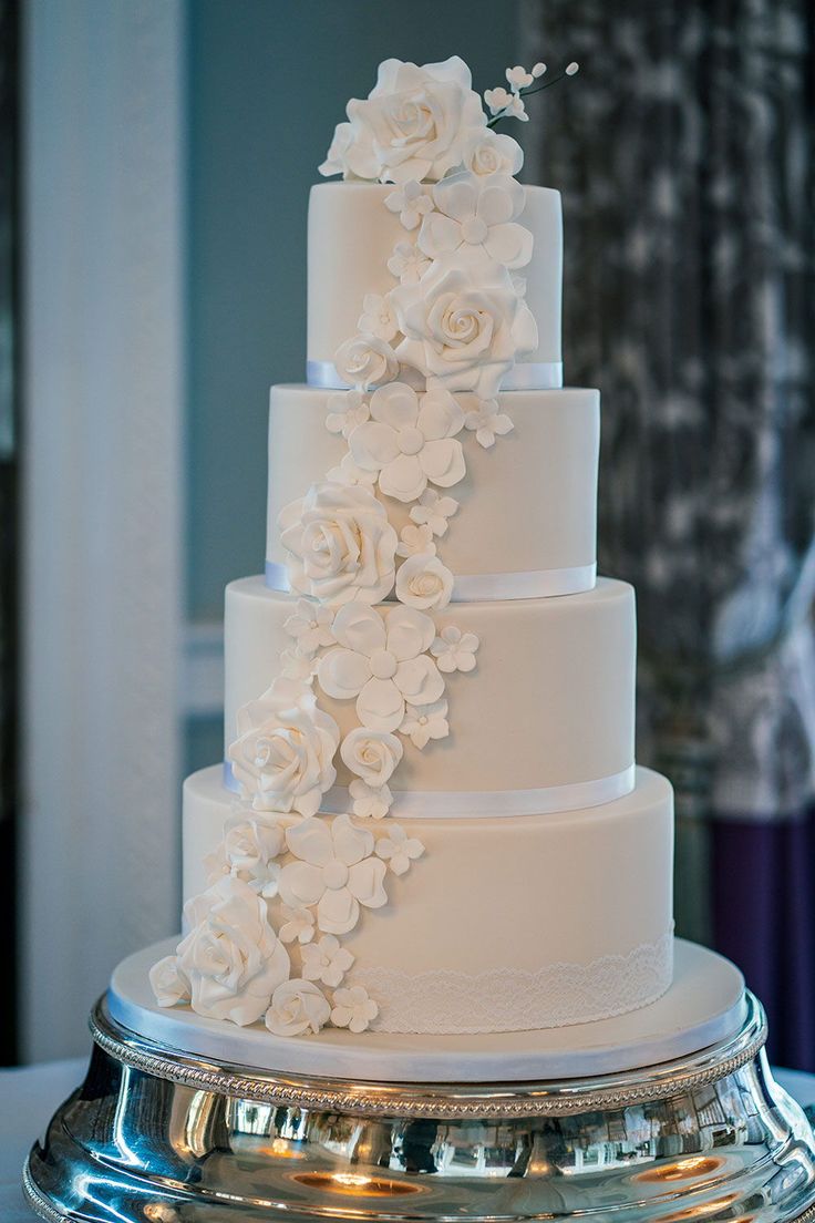 a white wedding cake with flowers on it