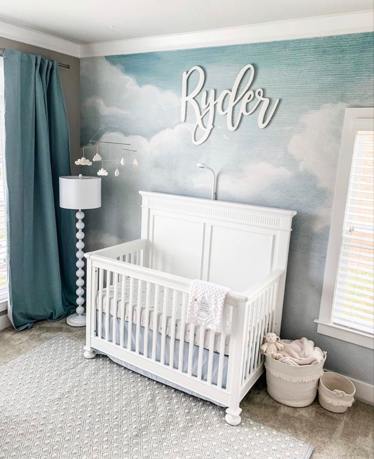 a baby's room with clouds painted on the wall and a crib next to it